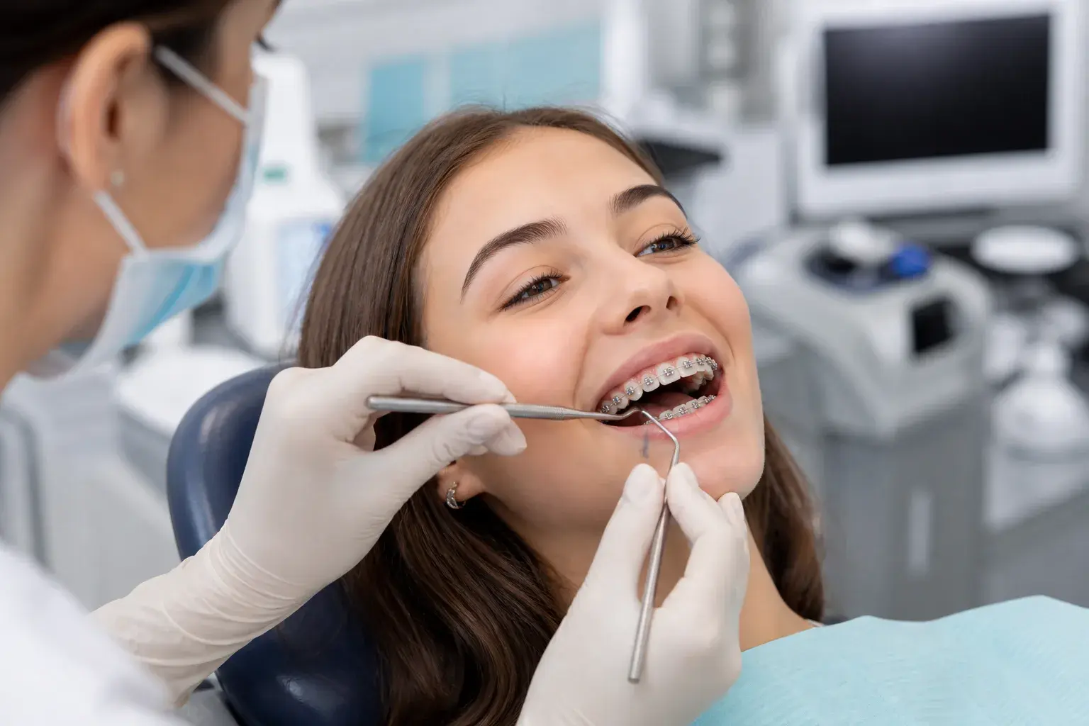 Interdental brush, floss threader, and braces model showing how to clean around brackets and wires