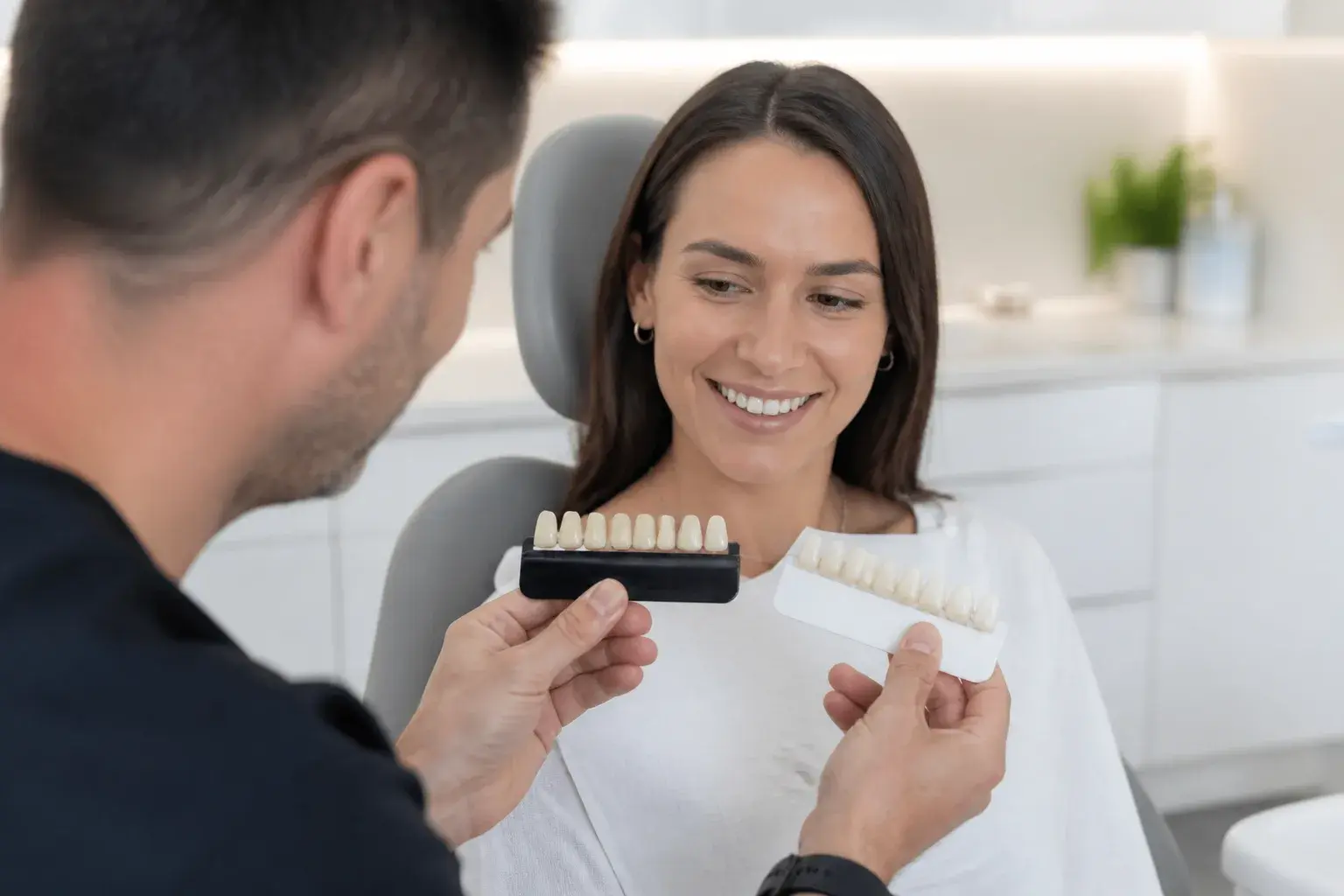Porcelain and composite veneer shade samples on a cosmetic dentistry tray comparing material choices