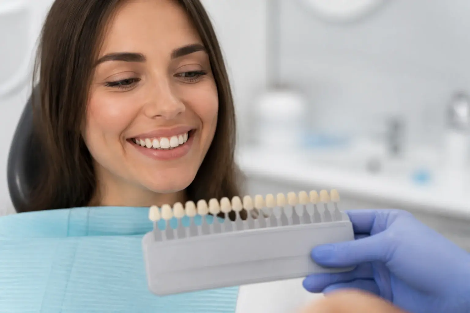 Tooth shade guide with enamel model showing common reasons teeth look yellow before whitening