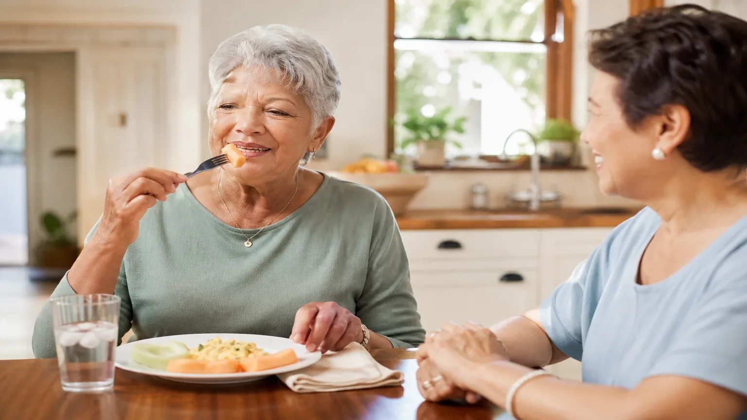 Denture wearer cutting soft food into small bites at a dinner table