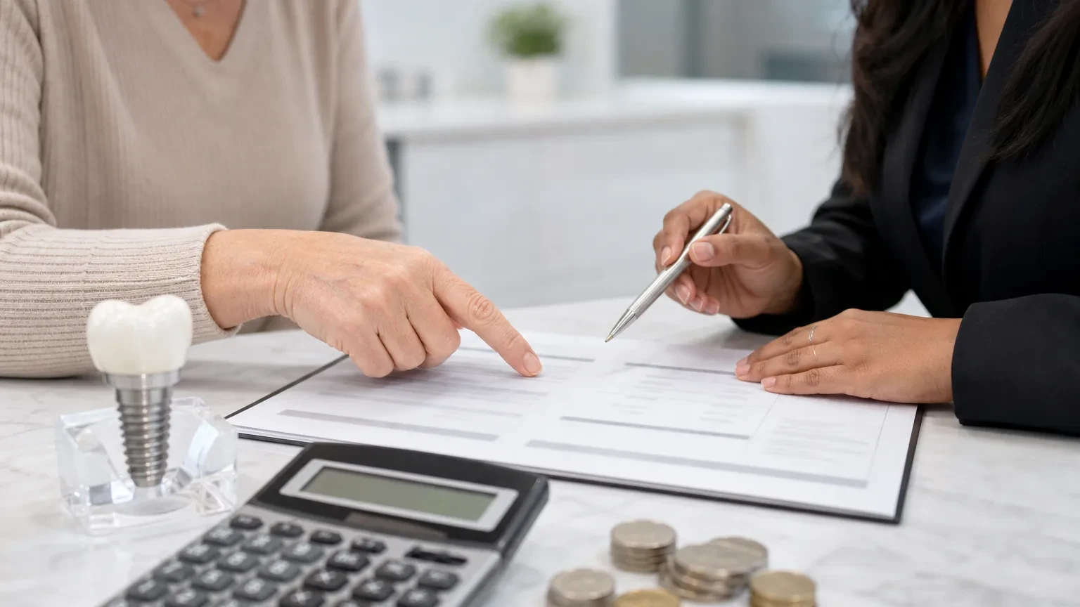 Dental treatment coordinator reviewing dental implant cost estimate with a patient