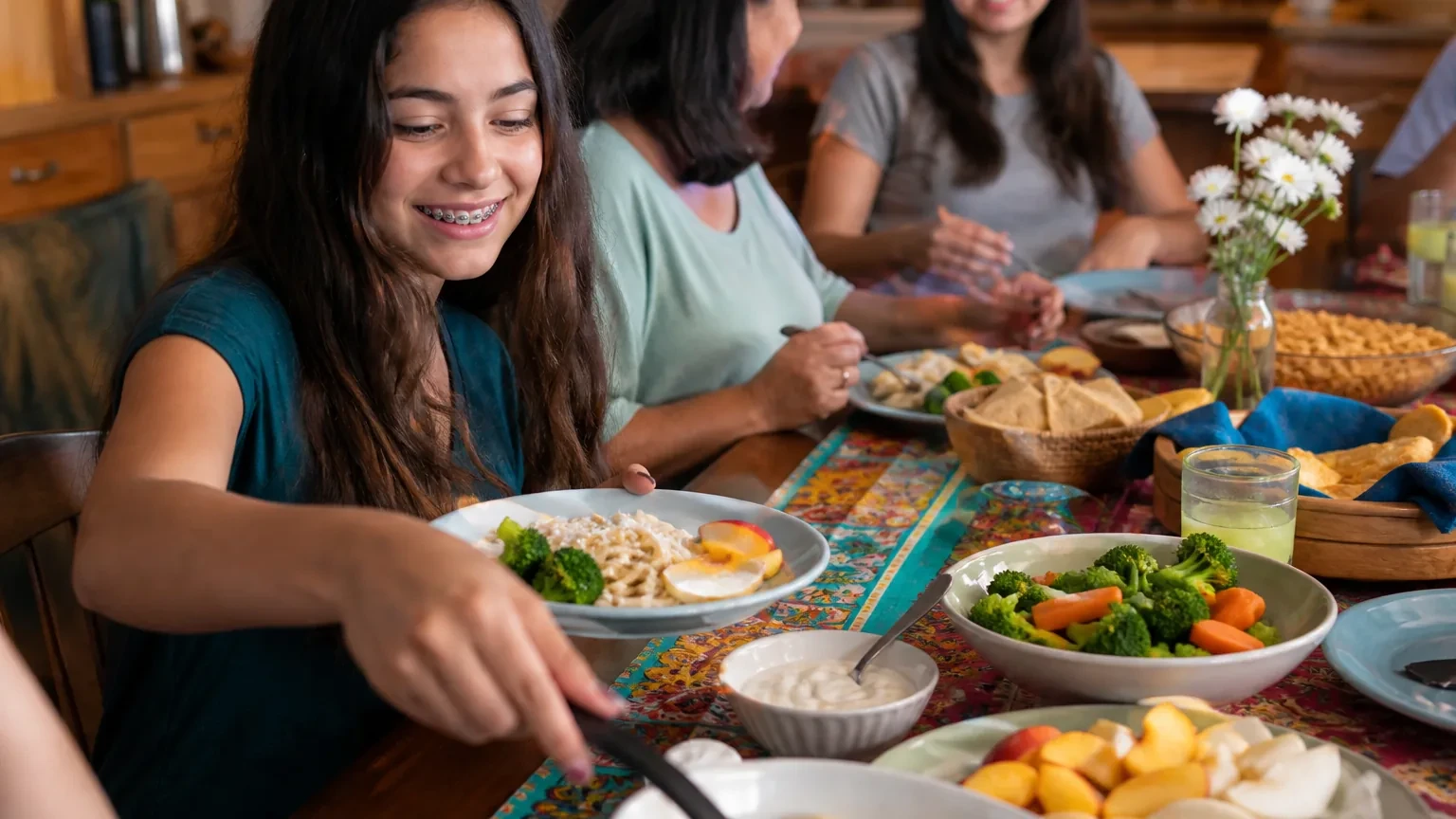 Braces-friendly meal with soft pasta, yogurt, sliced fruit, and water