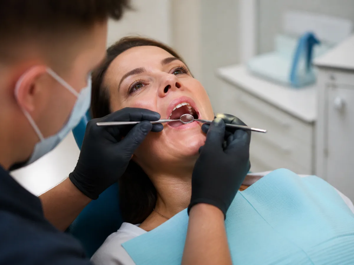 Dental assistant reviewing bleeding instructions with gauze and written aftercare sheet