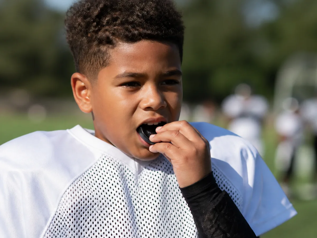 Dentist checking the fit of a youth sports mouthguard