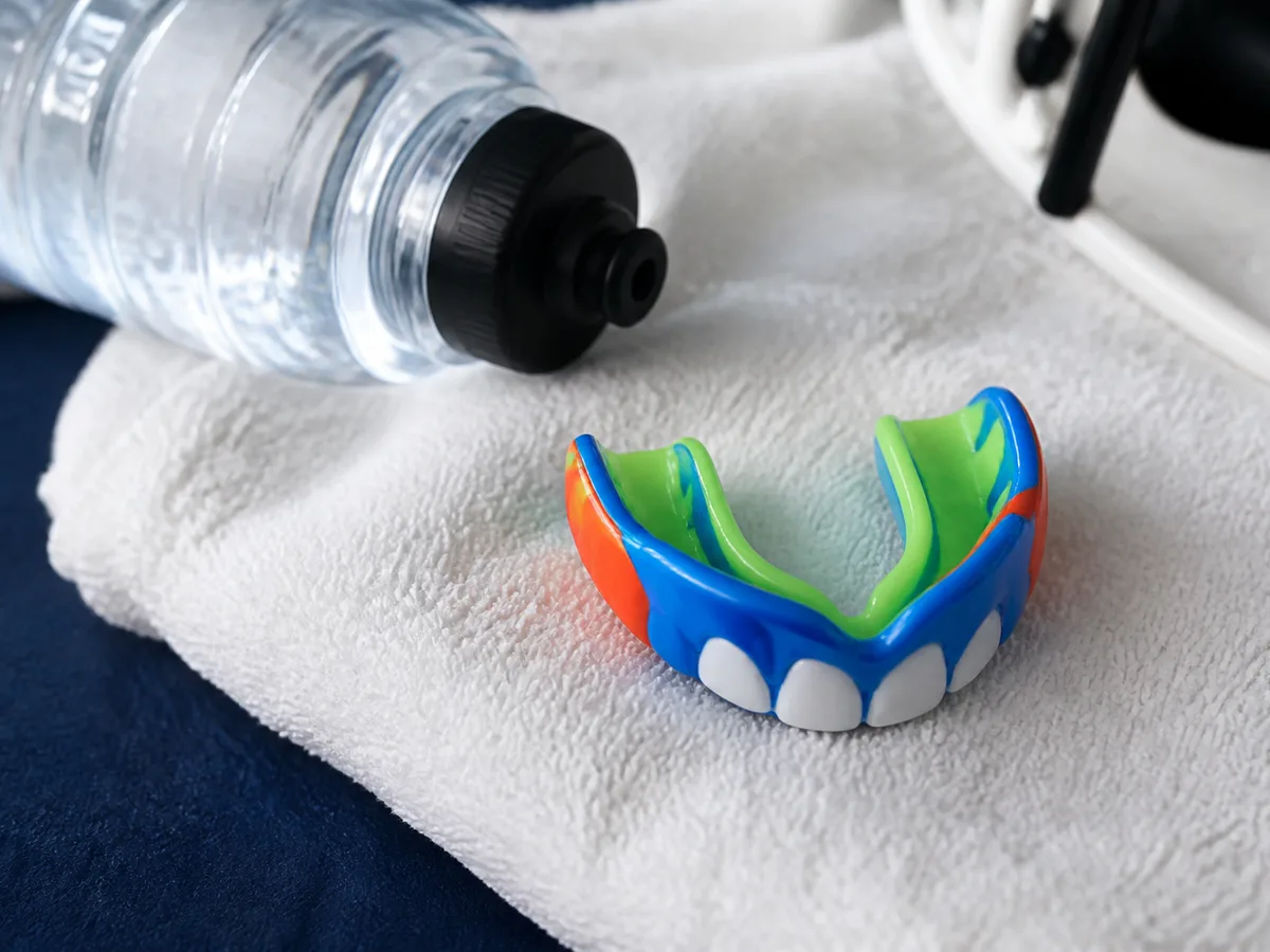 Parent placing a clean mouthguard in a ventilated sports case