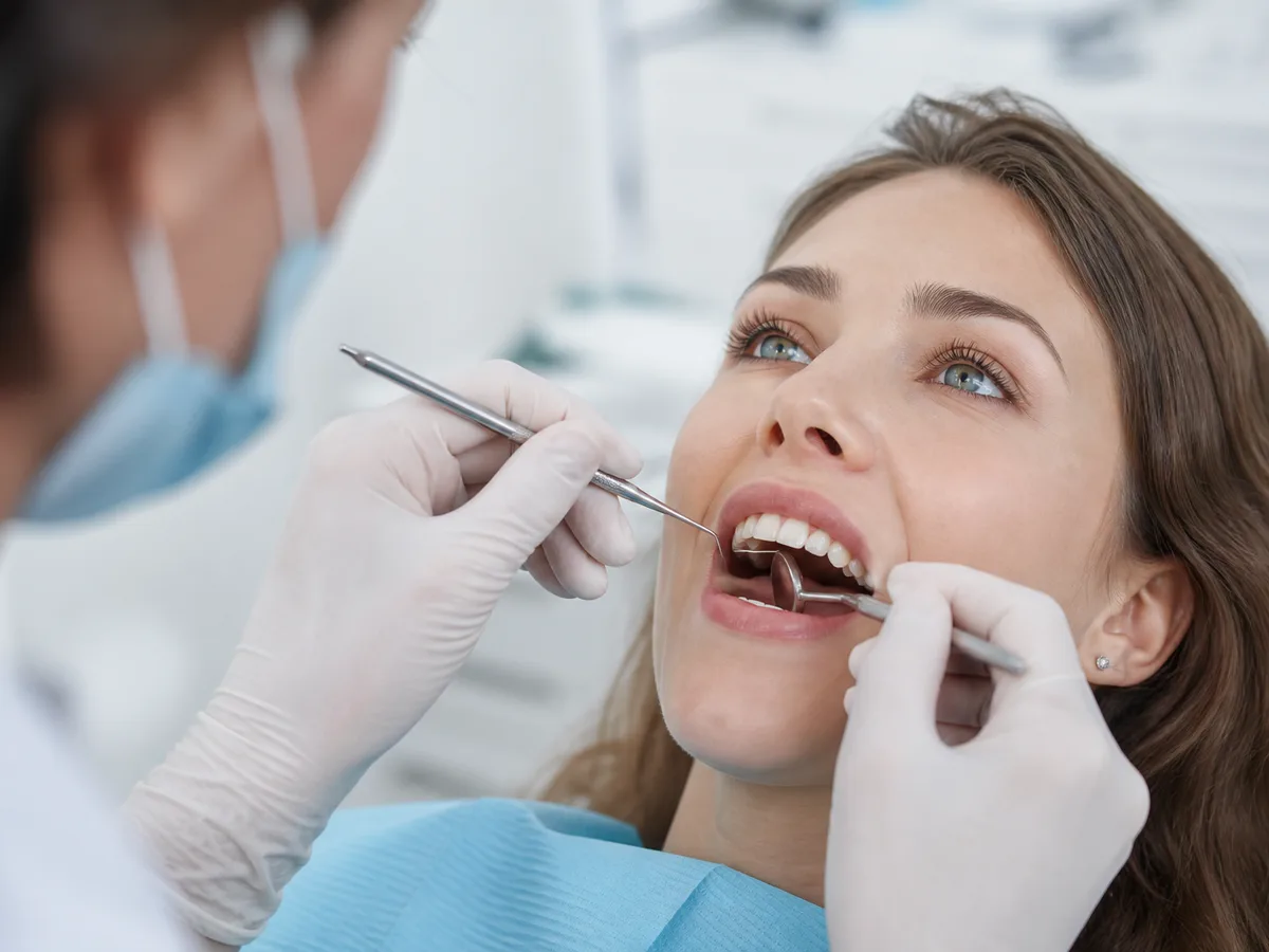 Patient points to a gumline area that traps food during a dental visit