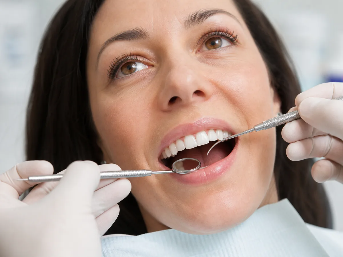 Patient holding a nightguard beside a veneer maintenance schedule