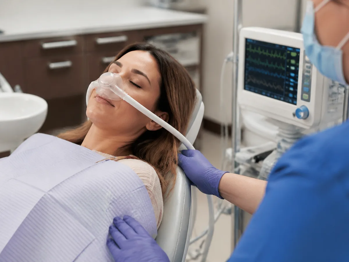 Clinician explaining conscious versus general anesthesia levels on a simple chart to a patient