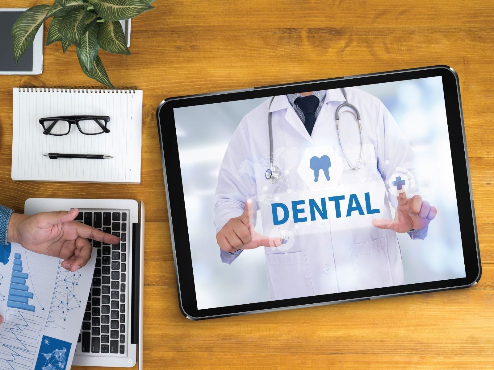 Dental website image on a tablet device laying on a wooden desk