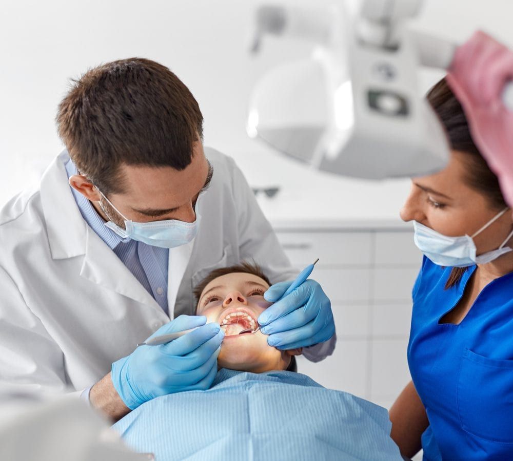 Dental Assistant Helping Dentist Treat Patient