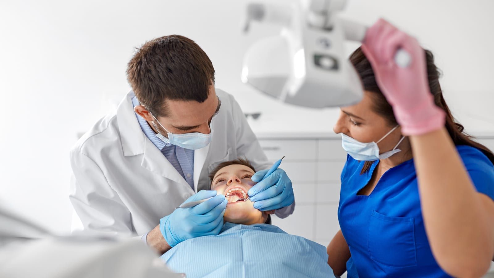Dental Assistant Helping Dentist Treat Patient