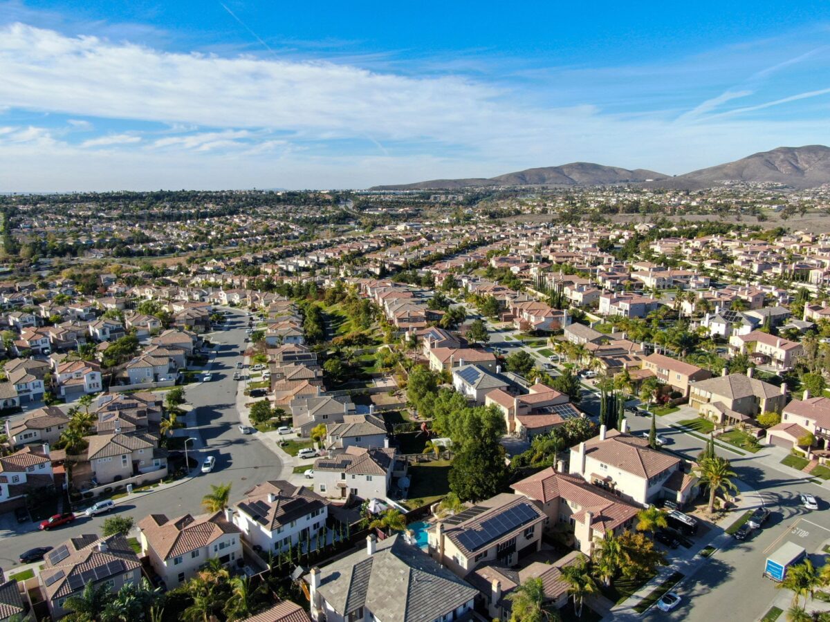 Aerial view of upper middle class neighborhood with identical residential subdivision houses during sunny day in Chula Vista, California, USA.