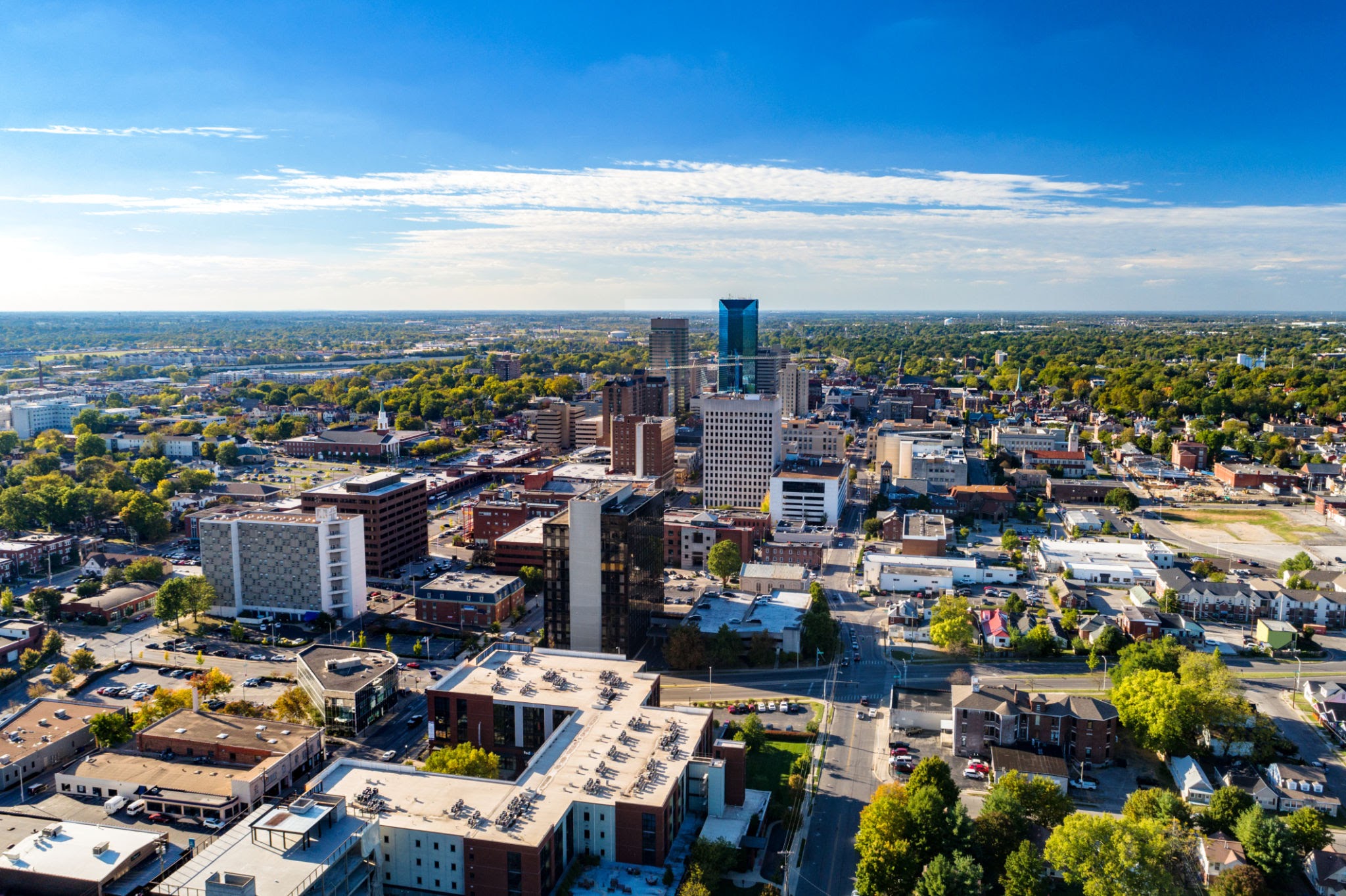 Aerial view of Downtown Lexington, Kentucky with a blue sky with clouds and the metropolitan area cityscape in the background.