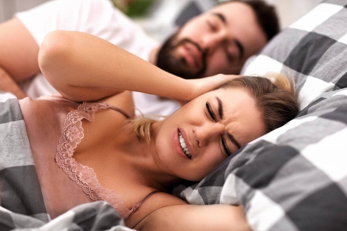 Adult couple suffering from snoring problem in bed