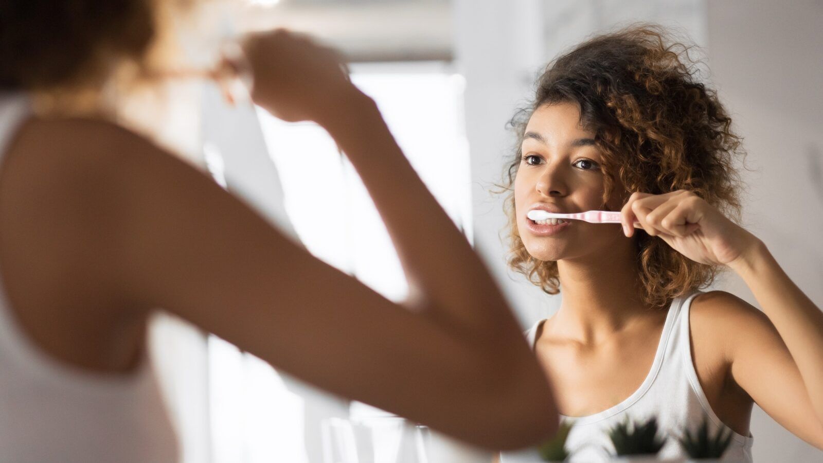 African american girl brushing teeth with toothbrush in bathroom, panorama