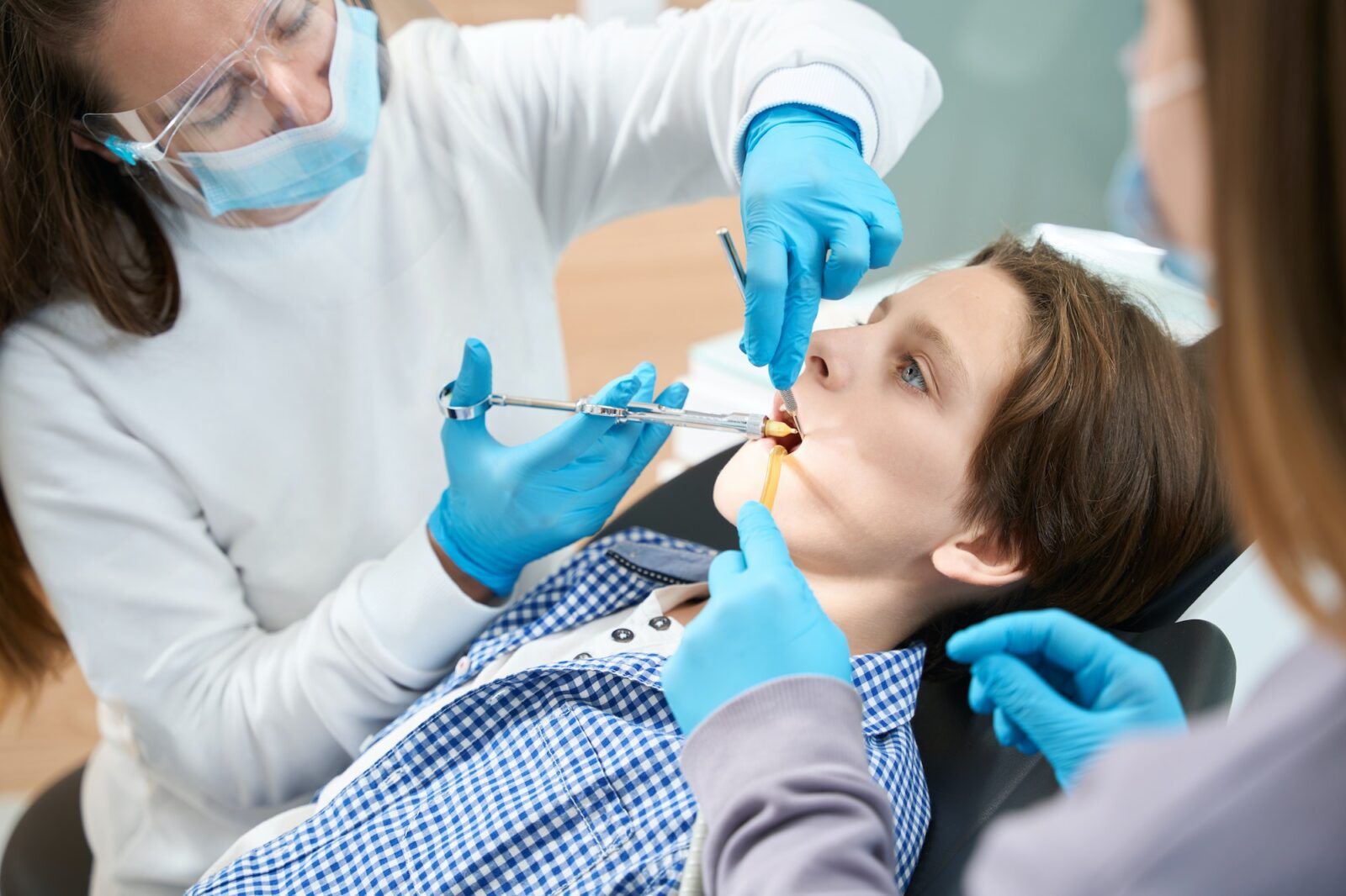 Child is given an injection of anesthesia before tooth extraction