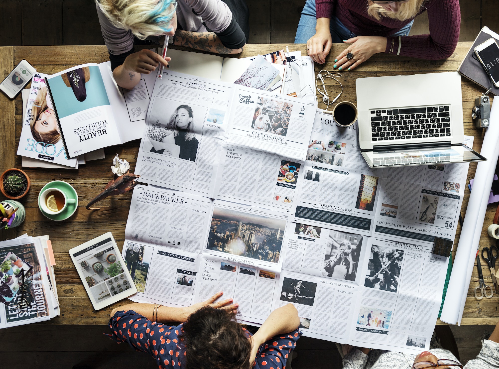 Colleagues discussing newspaper articles