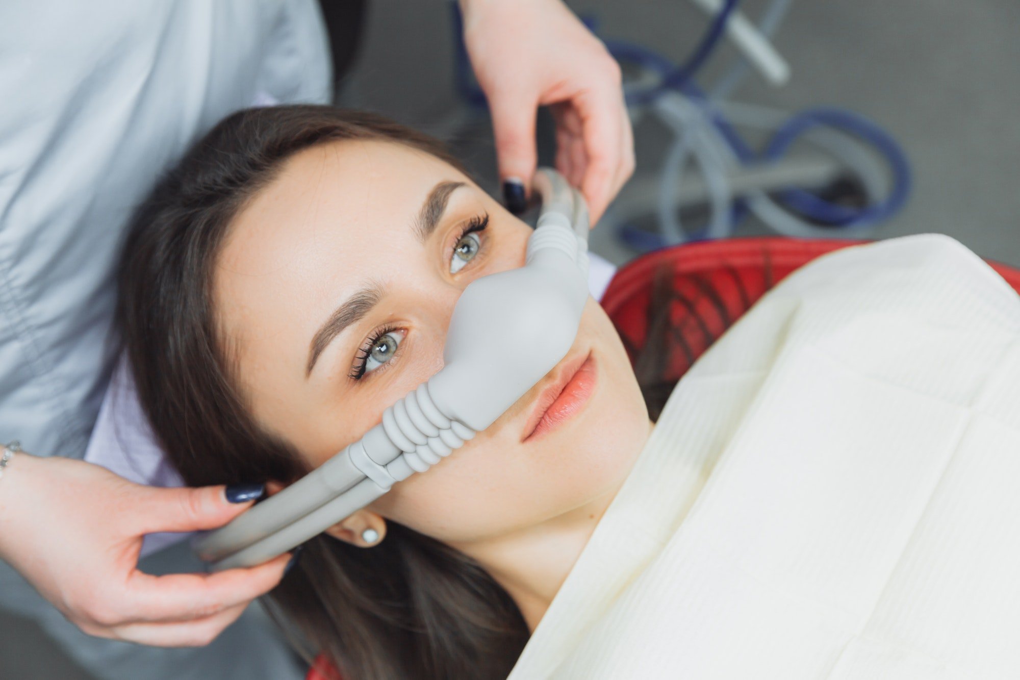 dentist puts inhalation sedative mask on his patient.