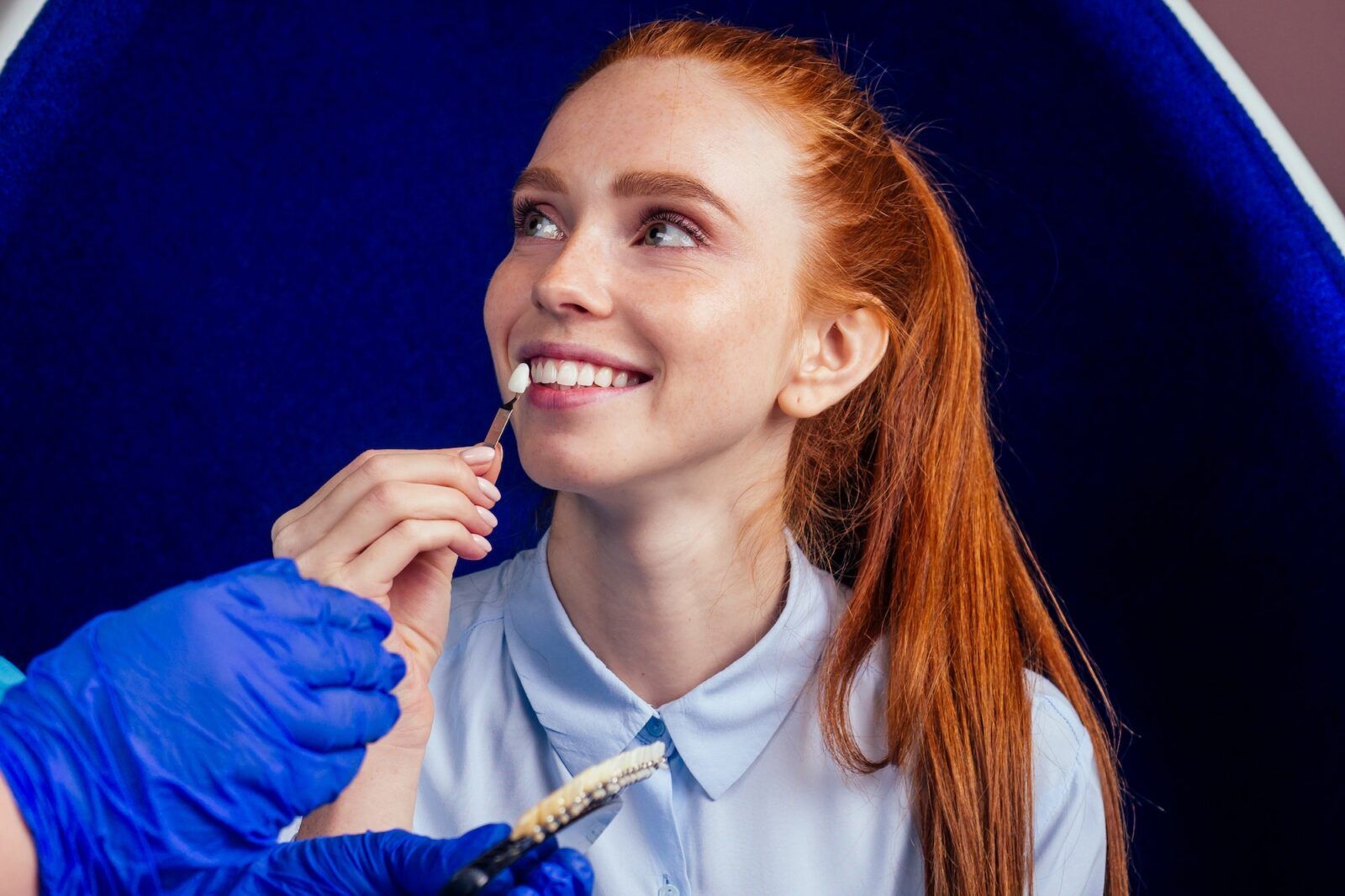 Dentist works on tooth crown in dental laboratory ultraviolet painting teeth