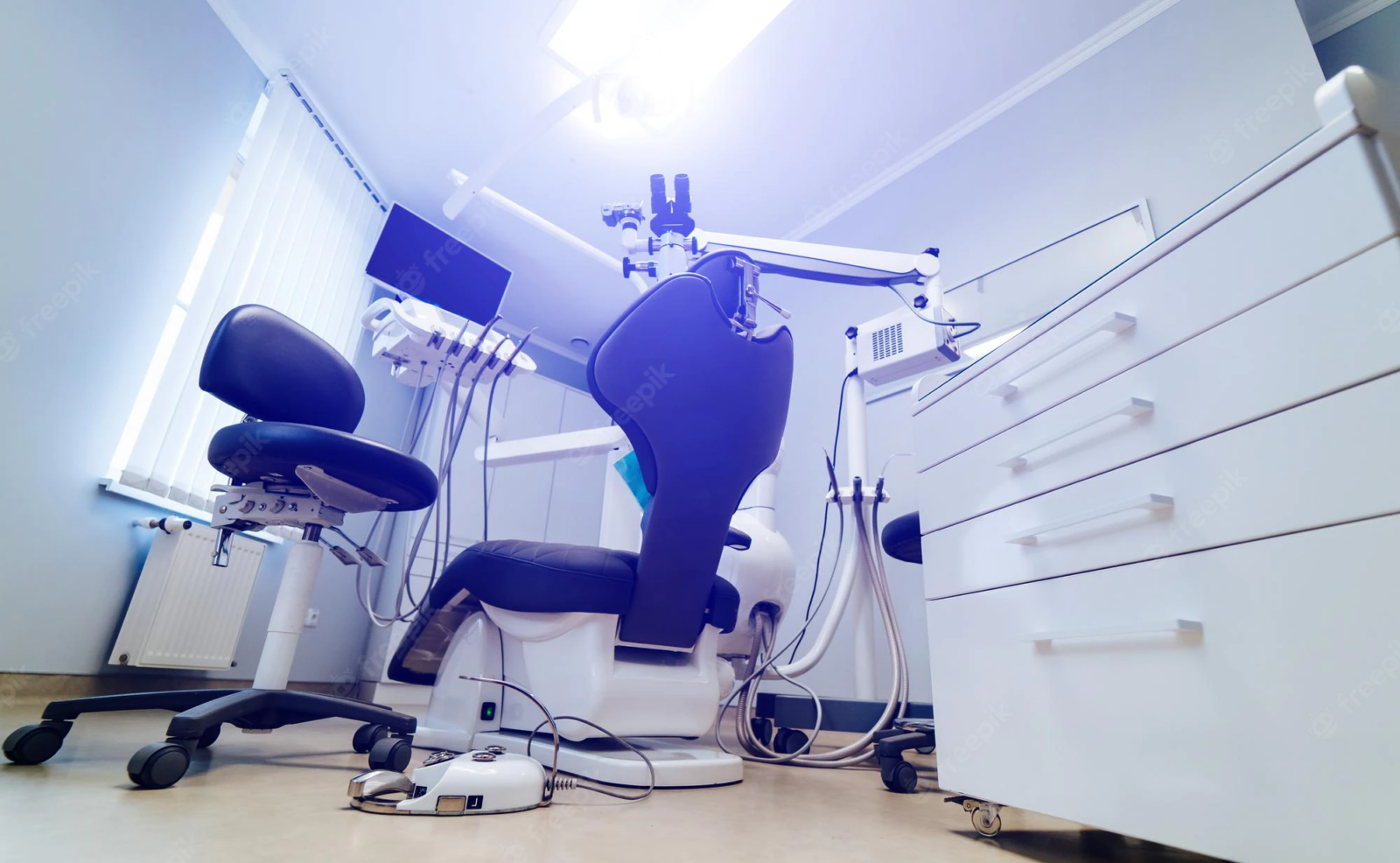 Modern dental patient rig including chair, lights, microscope, and computer