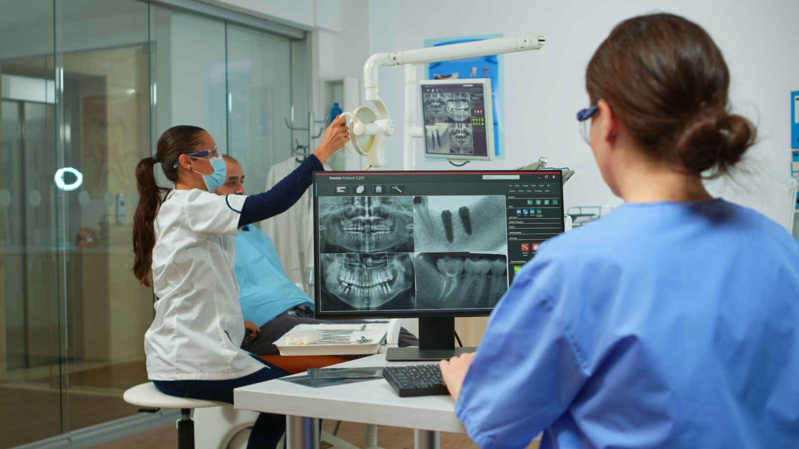 Nurse analysing digital x-ray sitting in front of pc