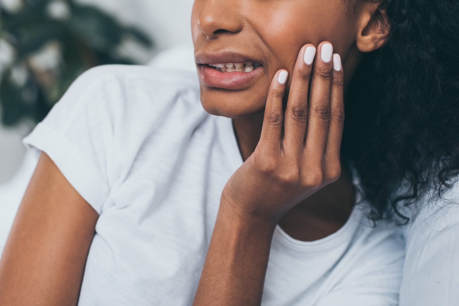 Partial view of young african american woman suffering from jaw pain