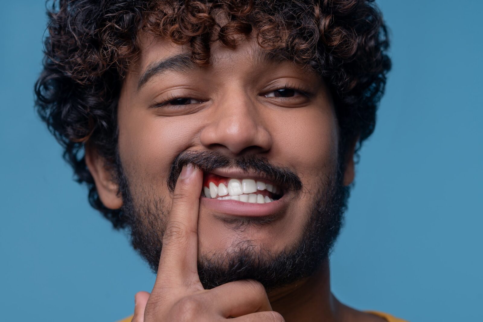 Young indian man showing his inflamed gums