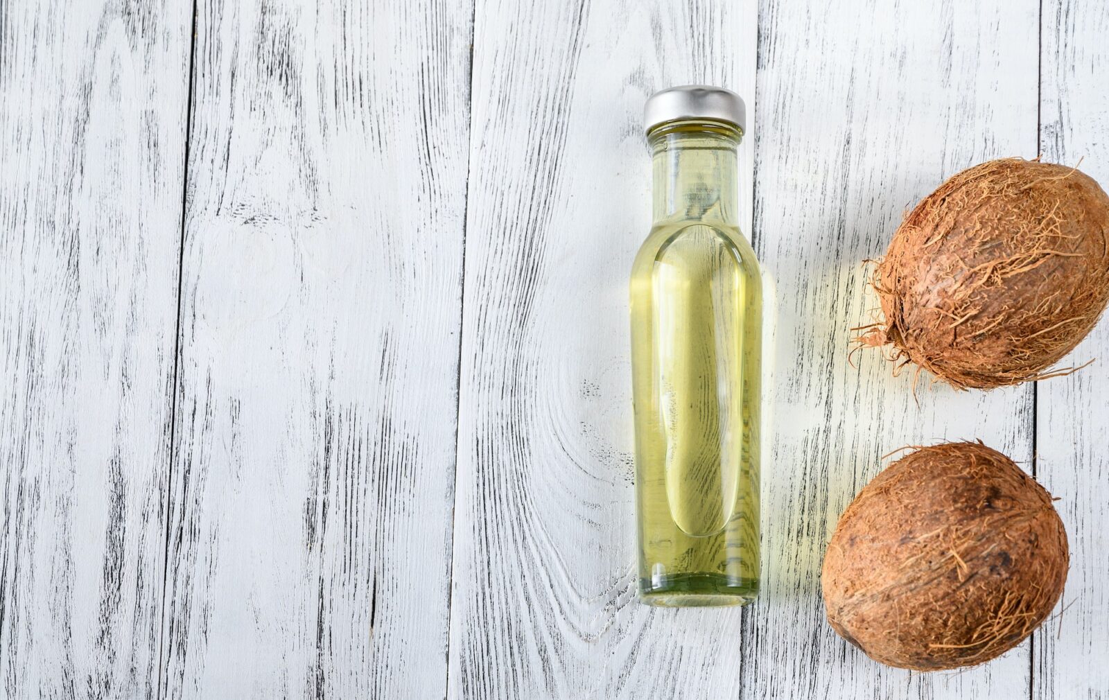 Bottle of coconut oil with coconuts