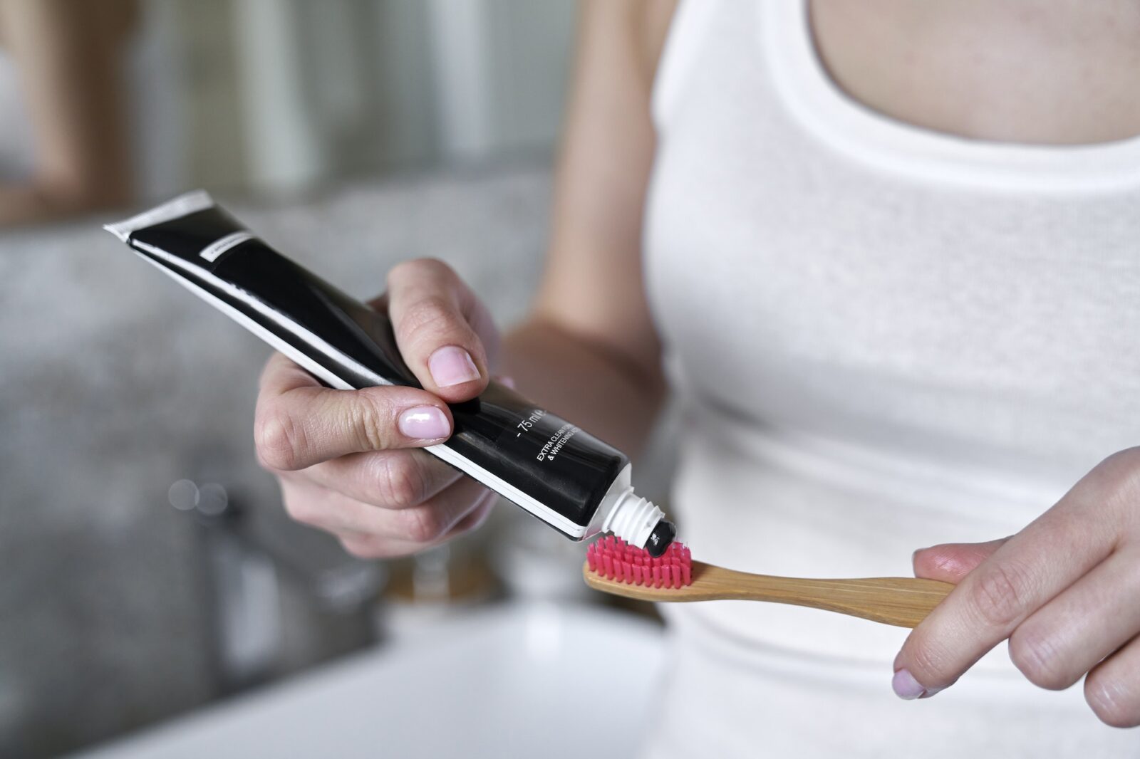 Detail of unrecognizable hand applying toothpaste on the toothbrush