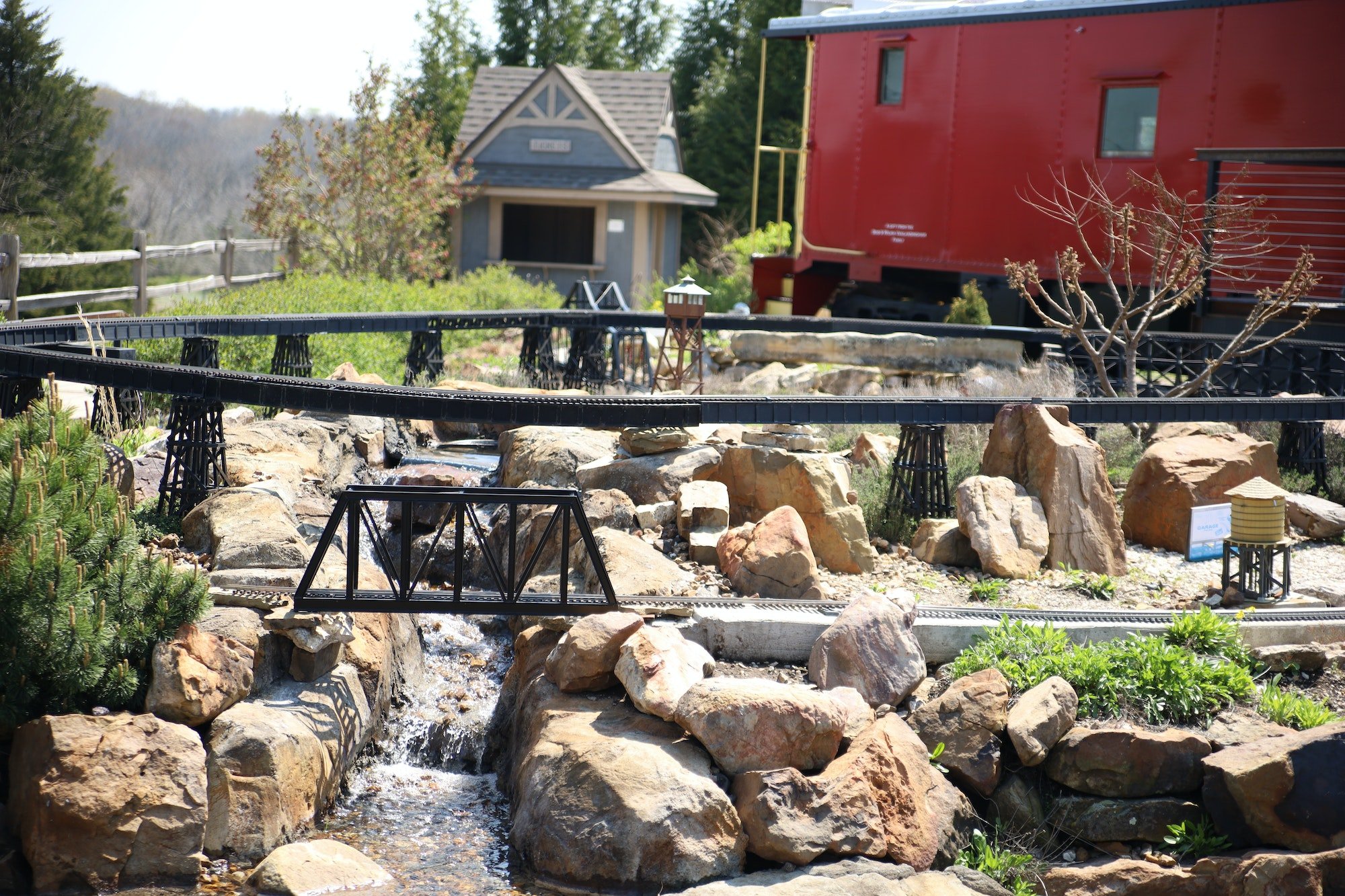 Small narrow stream surrounded by rocks and buildings in the Overland Park Arboretum in Kansas