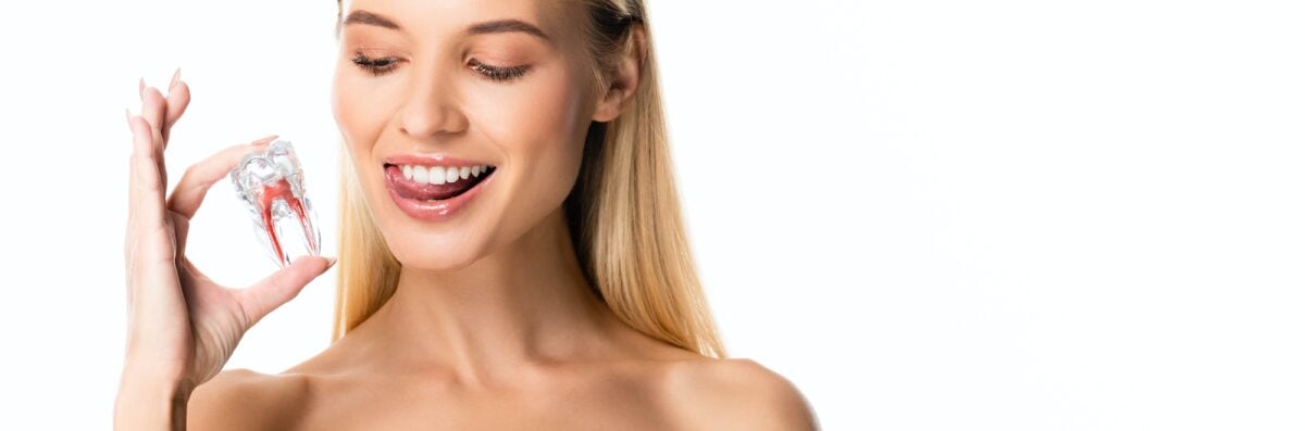 panoramic shot of naked woman with white teeth holding tooth model isolated on white