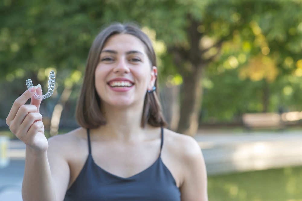 girl holding a clear ortho aligner